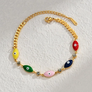 Macro detail of gold stainless steel bracelet with colorful evil eye charms and rhinestones
