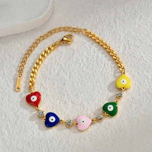 Detailed macro of golden stainless steel heart charms with evil eye motifs and rhinestones