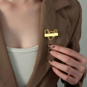 Golden stethoscope heart brooch made of stainless steel on a brown suit lapel