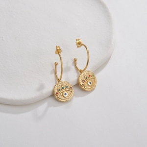 Detail of 14K gold square hoop earring with hammer-textured evil eye pendant and zircon