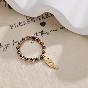 Detail of beaded ring with golden feathers charm and multifaceted iridescent beads