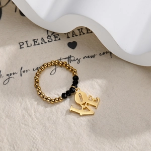 Close-up of beaded ring with gold spheres, black faceted beads, and a LOVE charm
