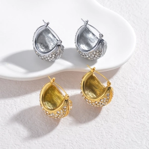 Luxury gold and silver half-hoop earrings with sparkling pavé crystals on white pedestal