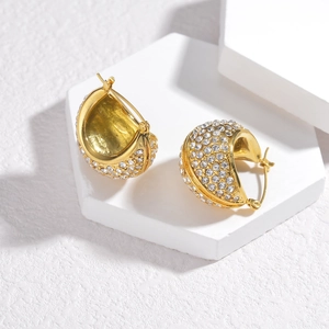 Chic gold dome hoop earrings with pavé crystals on white geometric platform