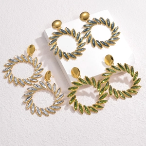 Detailed view of three pairs of rhinestone hoop earrings in blue, white and green colors