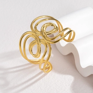 Chunky gold cutout open cuff bracelet with abstract swirl lines and embossed texture
