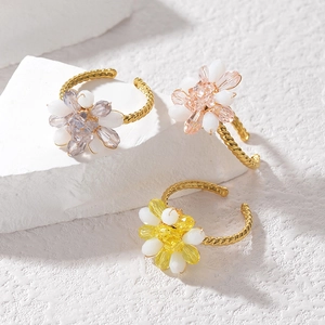 Detailed macro view of colorful flower rings with crystal beads and gold twisted bands