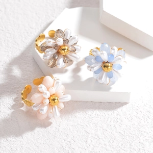 Detail of beaded flower rings with colorful petals and golden adjustable bands