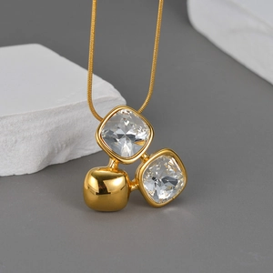 Detail showing square zircon pendants on a sleek 18K gold snake chain necklace