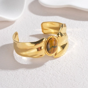 Vintage style gold-plated cuff bracelet with irregular texture and tiger eye gemstone