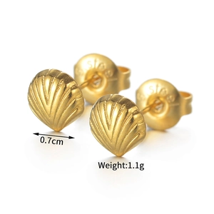 Gros plan sur les boucles d'oreilles coquillage en acier doré montrant la taille de 0.7cm