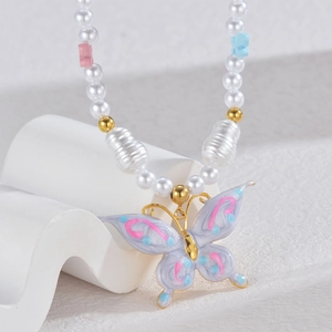 Colorful butterfly pearl necklace with gold accents on a white geometric display stand