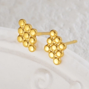 Polished 18K gold stainless steel geometric rhombus stud earrings on white ceramic tray