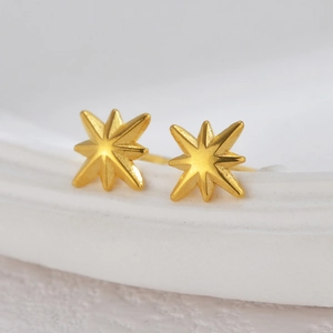 Minimalist 18K gold star stud earrings with a matte finish on white display stand