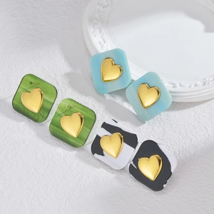 Detailed view of square heart studs in vintage green, light blue, and black marble patterns
