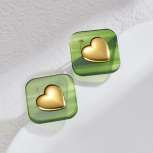 Vintage green textured square earrings with a metallic gold heart center on white background