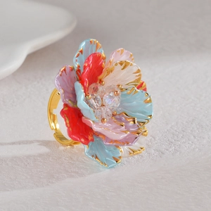 Bague florale baroque vintage avec pétales colorés et cristal sur fond texturé blanc épuré