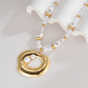 Detail of gold pendant necklace with baroque pearls and hollow golden circle charm