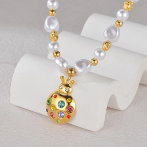 Detail of baroque pearls and ladybug pendant with colorful crystals on 18K gold chain