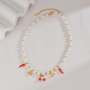 Détail du collier en perles d'acier inoxydable avec breloques cerise et fermoir mousqueton