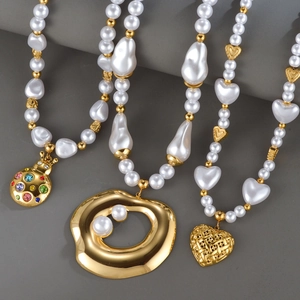 Three gold-plated pearl necklaces with heart, beetle, and disc pendants on minimalist background