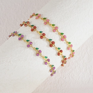 Detail of cute cherry bracelets in pink, red, and purple with golden metal chains
