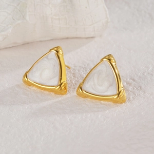 French vintage gold triangle studs with white pearlescent inlay on a stone background