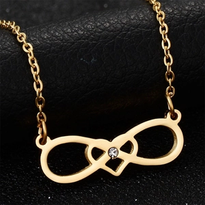 Macro shot of gold infinity heart pendant with sparkling cubic zirconia on black leather