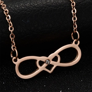 Detailed macro view of infinity symbol and interlocked hearts necklace in rose gold