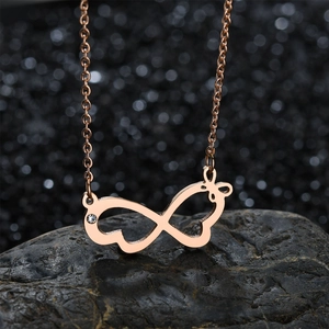 Rose gold infinity symbol and bow pendant necklace with zircon on a black stone base