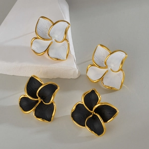 Boucles d'oreilles fleurs élégantes noir et blanc avec bord doré sur fond de pierre