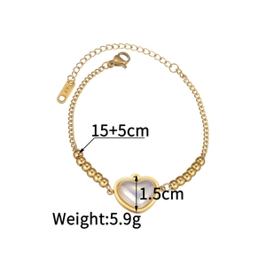 Dettaglio del bracciale dorato con perla a cuore, chiusura a moschettone e catenina