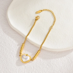 Bracciale minimalista con cuore placcato oro 18KGP e perline su fondo di marmo