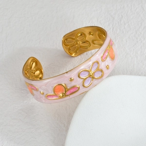 Detail of vintage gold-plated cuff bracelet with pink marble enamel and floral patterns