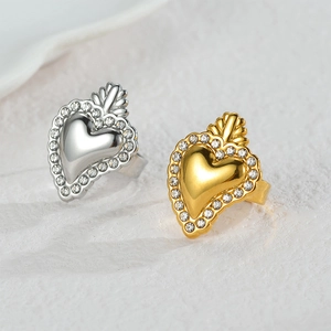 Elegant gold and silver heart rings with pavé crystals on a textured stone surface
