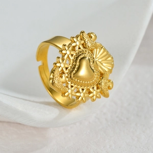 Golden adjustable heart ring with embossed flowers and wings on white background
