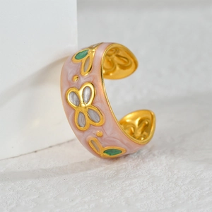 Macro view of 18K gold ring featuring pink marble enamel and butterfly pattern
