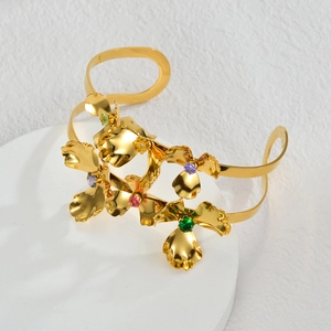 Gold flower bangle with colorful zircon stones on minimalist white stone base