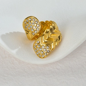 Macro view of gold plated wavy open ring with sparkling white zircon stones