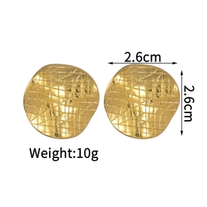 Close-up of golden square earrings featuring a quilted texture and polished metal finish