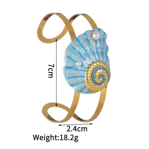 Detail view of gold ocean bracelet featuring blue shell motif with pearl accents and size specs