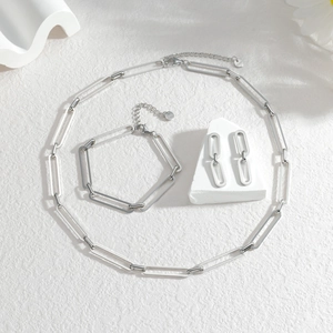 Détail de l'ensemble collier, bracelet et boucles d'oreilles trombone en acier inoxydable
