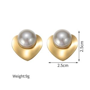 Detail view of 18K gold-plated heart earrings with pearl center and 2.5cm size markings