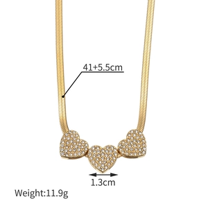 Détail du collier chaîne serpent plaqué or 18K avec trois pendentifs cœurs strass