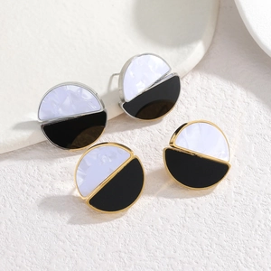 Minimalist black and white marble earrings in gold and silver finish on stone background