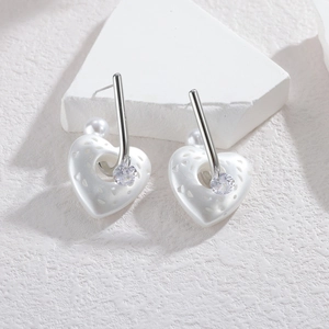 Minimalist stainless steel earrings featuring heart charms, pearls, and zircons on a white base