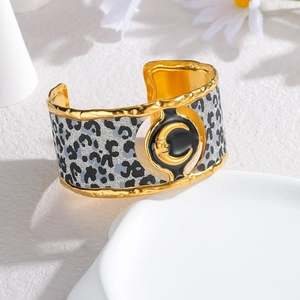 Wide leopard print stainless steel cuff bracelet with golden moon face relief design