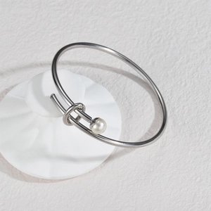 Minimalist silver open cuff bracelet with polished metal knot and pearl accent