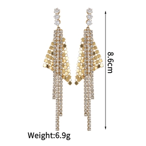 Détail des boucles d'oreilles géométriques à franges avec strass et mailles écailles