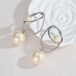 Boucles d'oreilles minimalistes en argent avec perles élégantes sur fond de marbre blanc